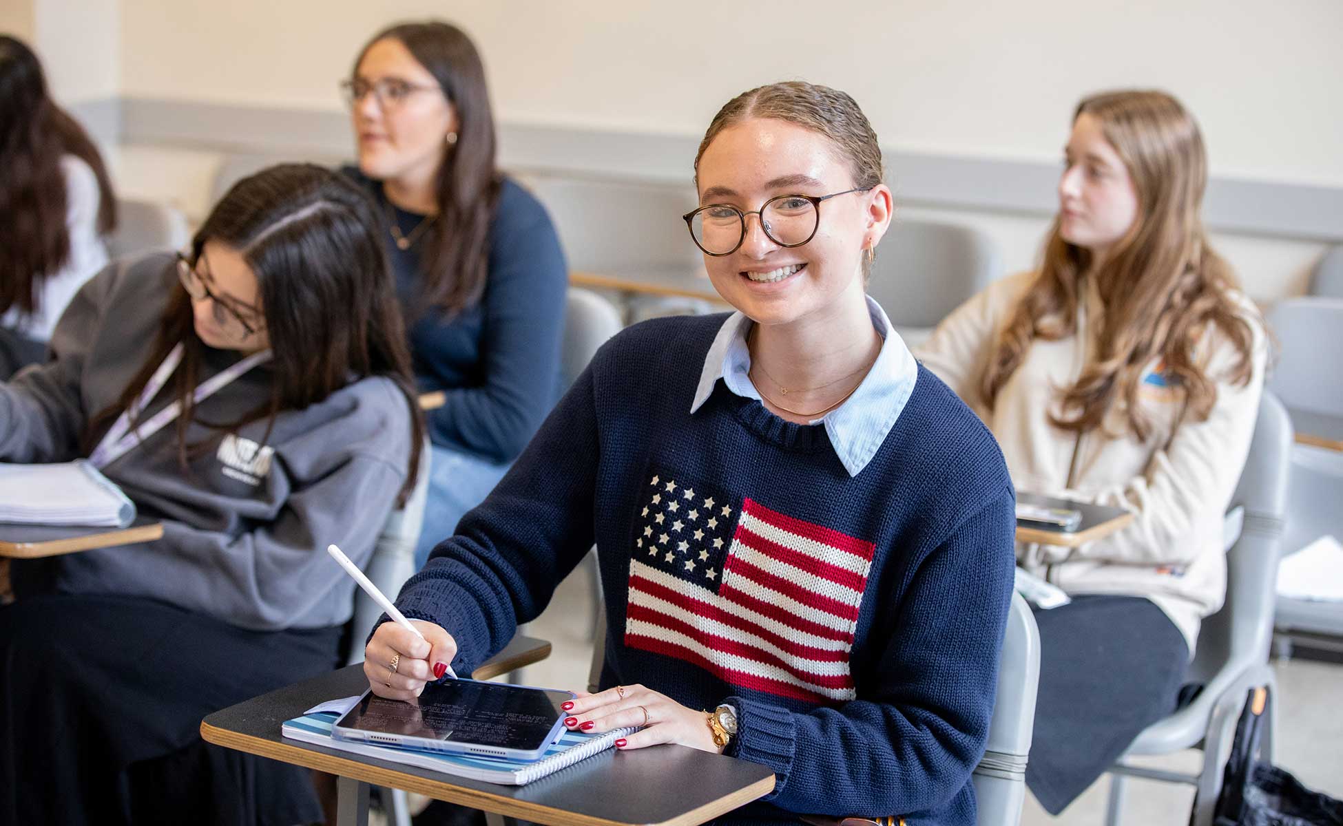 LCW student smiling while taking notes in class