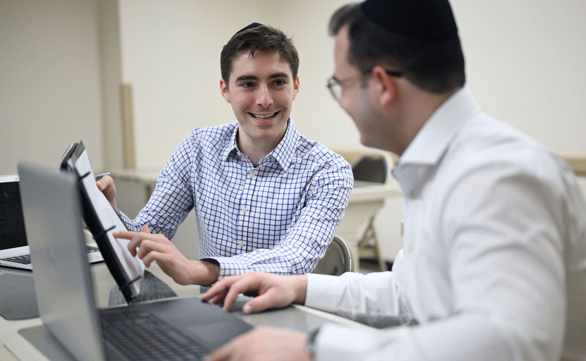 Two students smiling while working together