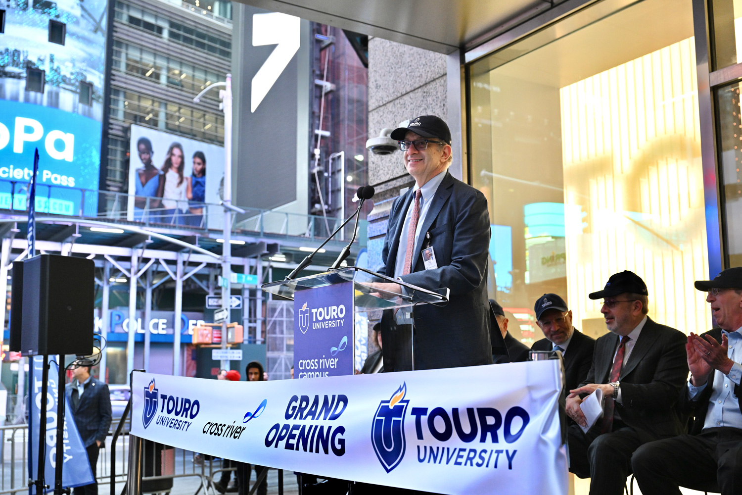 Dr. Kadish speaking outside on a stage at the cross river campus opening.